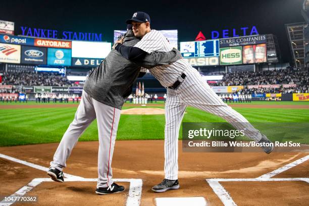 Manager Alex Cora of the Boston Red Sox shakes hands with Manager Aaron Boone of the New York Yankees before game three of the American League...