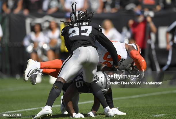 Reggie Nelson and Dominique Rodgers-Cromartie of the Oakland Raiders tackles Carlos Hyde of the Cleveland Browns short of a first down during the...