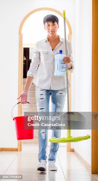 glimlachend volwassen vrouw houden van reinigingsapparatuur - daily bucket stockfoto's en -beelden