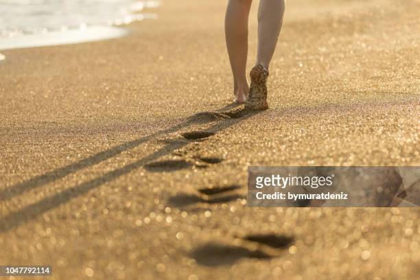 woman walking on send - human foot prints stock pictures, royalty-free photos & images