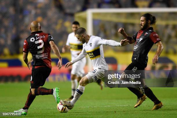 Nahitan Nandez of Boca Juniors controls the ball under pressure from Clemente Rodriguez and Franco Zuzulini of Colon during a match between Boca...