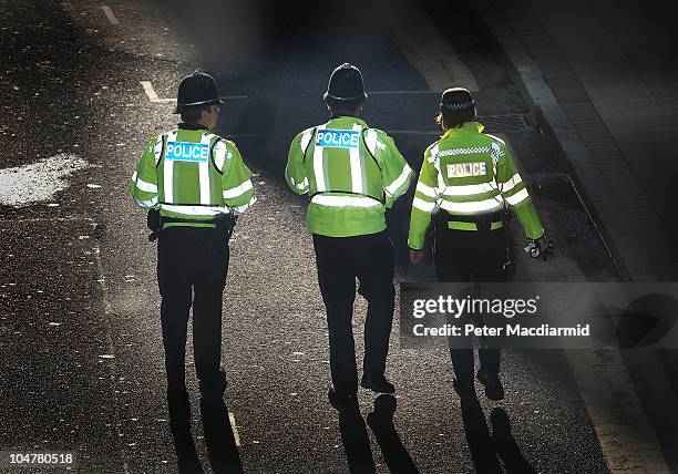 Police are lit by reflected window light as they patrol next to the Conservative Party Conference on October 4, 2010 in Birmingham, England. On the...