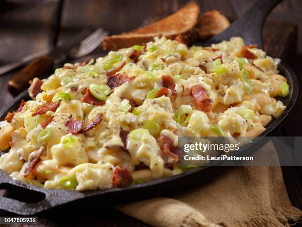 breakfast poutine with hollandaise sauce, scrambled eggs, bacon and cheese curds - poutine stock pictures, royalty-free photos & images