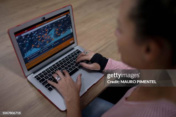 Cecilia Oliveira, Fogo Cruzado founder, shows Fogo Cruzado App in her laptop in Rio de Janeiro, Brazil on October 08, 2018. - Fogo cruzado app...