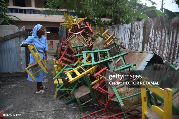 Nun recovers chairs from a school damaged by an earthquake that hit the North of Haiti on October 6 in Gros Morne, on October 8, 2018. 9-magnitude...