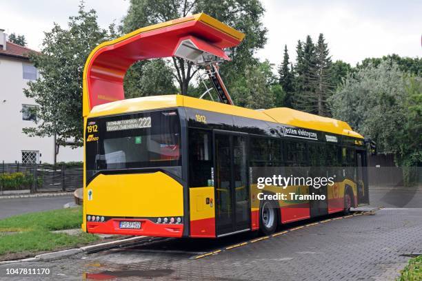 modern electric bus on the charging station - warsaw bus stock pictures, royalty-free photos & images