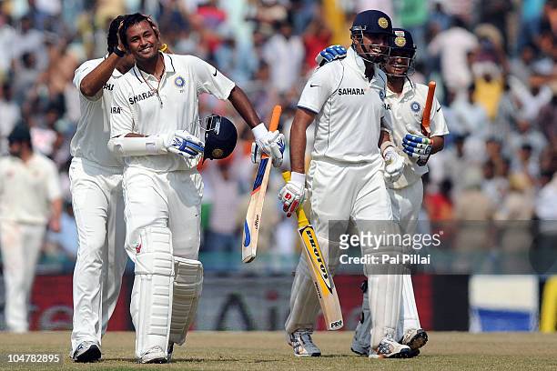 Pragyan Ojha of India is congratulated by teammate Murali Vijay as VVS Laxman and Suresh Raina celebrate after their win on day five of the First...