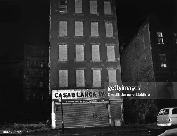 Nighttime view of the facade of an abandoned building, with the former 'Casablanca Meat Market' located on the ground floor, in the South Bronx...