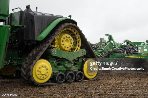 large john deere tractor with seeding equipment - caterpillar equipment stock pictures, royalty-free photos & images