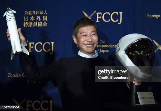 Yusaku Maezawa, chief executive officer of Zozo Inc., poses with a model of the SpaceX BFR rocket and the spacesuit's helmet during a news conference...