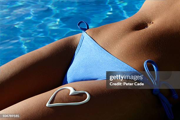 womans body with suncream heart - tanned body stock pictures, royalty-free photos & images