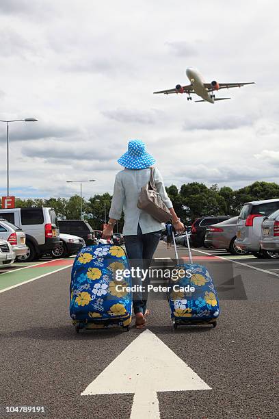 woman with suitcases in airport car park - london airport stock pictures, royalty-free photos & images