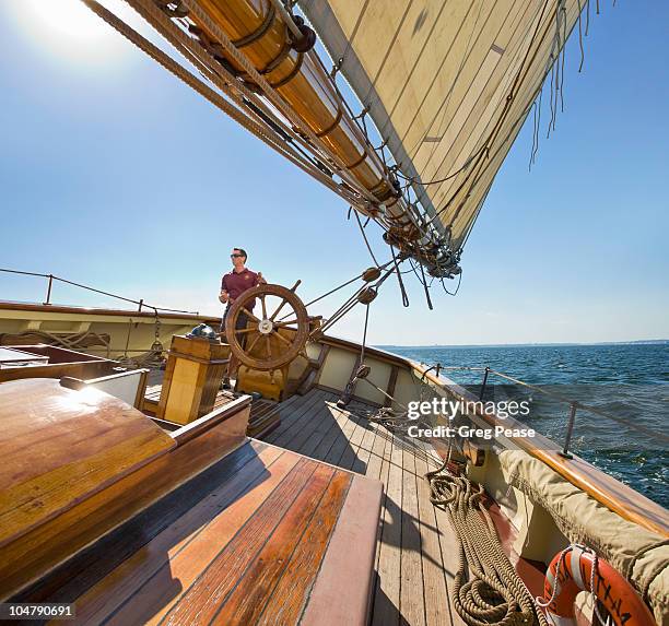 captain at the helm of pride of baltimore ii - pirate ship fotografías e imágenes de stock