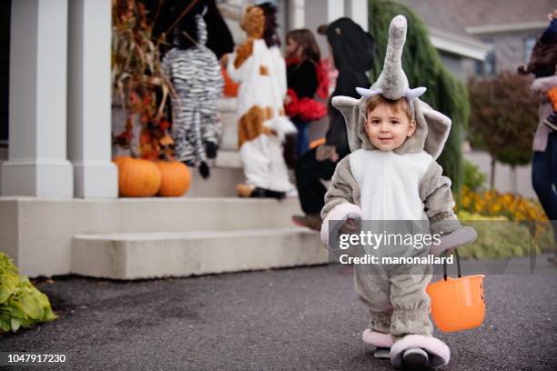 kleine jongen met syndroom van down en zijn vrienden gekleed in kostuums van halloween - halloween kids stockfoto's en -beelden