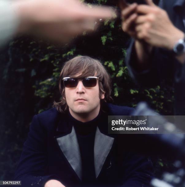 John Lennon of the Beatles in Chiswick House grounds, London, during the making of promotional films for the single 'Rain' and 'Paperback Writer',...