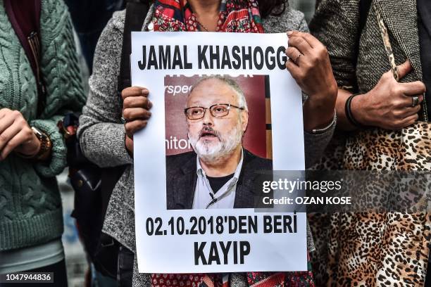 Woman holds a portrait of missing journalist and Riyadh critic Jamal Khashoggi reading "Jamal Khashoggi is missing since October 2" during a...