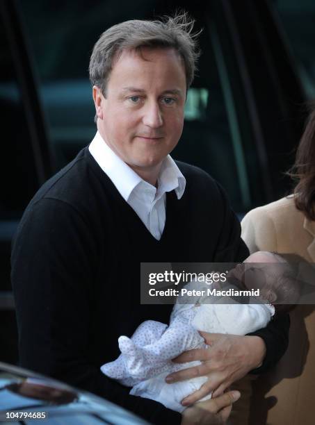 Prime Minister David Cameron holds his baby daughter Florence as he arrives at the Conservative Party Conference on October 5, 2010 in Birmingham,...