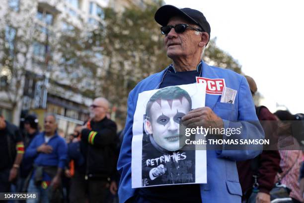 Protestor holds a picture of French President Emmanuel Macron during a one-day nationwide strike over President Emmanuel Macron's policies on October...