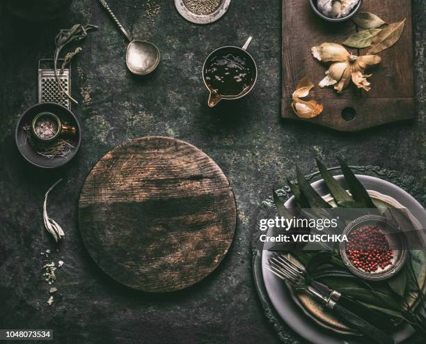 dark rustic food background with empty cutting board, sauce and table setting - food rustic stock-fotos und bilder