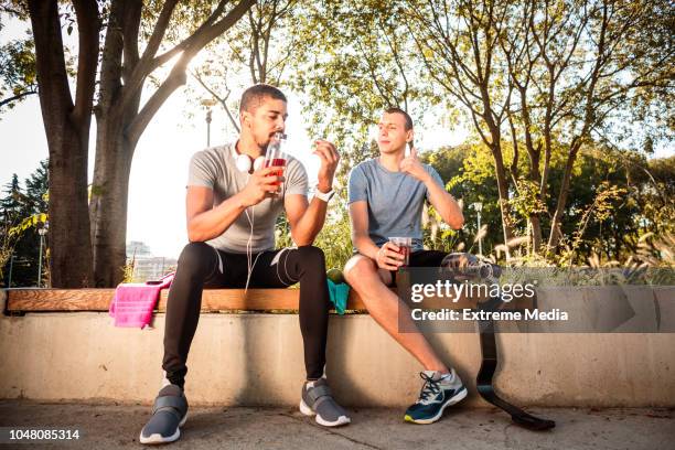 sports friends resting and hydrating after exercise - disabled extreme sports stock pictures, royalty-free photos & images