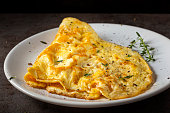 Scrambled eggs or omelette made from eggs and cheese with herbs