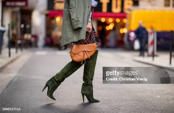 Alexandra Lapp is seen wearing a plaid kilt skirt from maje, an I love Paris sweatshirt from a souvenir shop in Paris, a green parka jacket with...