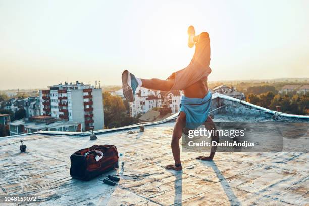 mann, der ausübung und hand stehend auf dem dach - breakdancing stock-fotos und bilder