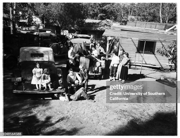 Old cars rebuilt in back yard as a hobby Eleven of fourteen Henkel children work on old autos, 17 November 1951. James Henkel Senior, father;Mrs...