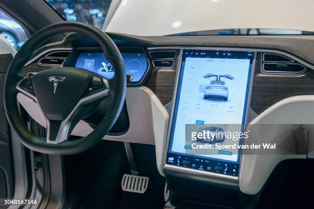 Luxurious interior on a Tesla Model X P90D full electric luxury crossover SUV car with a large touch screen and dashboard screen on display at...