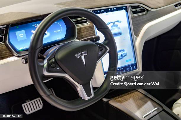 Luxurious interior on a Tesla Model X P90D full electric luxury crossover SUV car with a large touch screen and dashboard screen on display at...