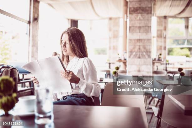 söt kvinna läsa tidningen och dricka kaffe - magazines on table bildbanksfoton och bilder