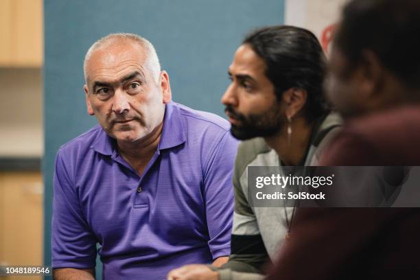 mental health professional talking to support group - group of mature men stock pictures, royalty-free photos & images