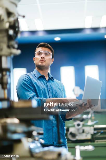 Latin engineer working on laptop and drill