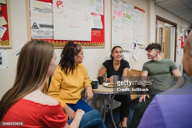 teenagers relaxing with tea at youth club - youth culture stock pictures, royalty-free photos & images
