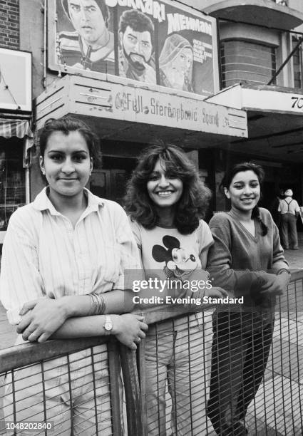 Three women, sisters Kuldip and Ranjit Sandhu, and Surinder Sandbar, standing in front of a cinema screening Bollywood crime film 'Sarkari Mehmaan',...