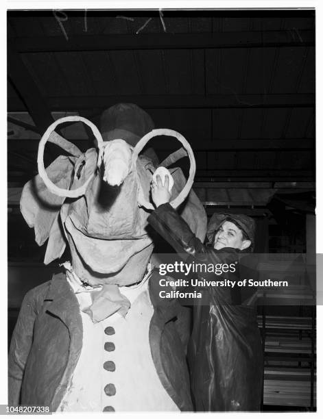 Preparation of floats for Rose Parade, 29 December 1951. Irving Yabner, wiping off elephant on South Pasadena float;Moe Bear, wiping off elephant on...