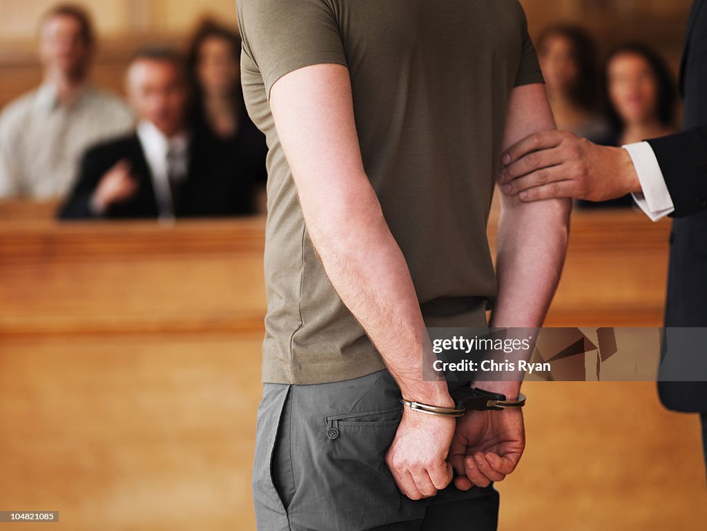 Handcuffed homme debout dans la salle d'audience