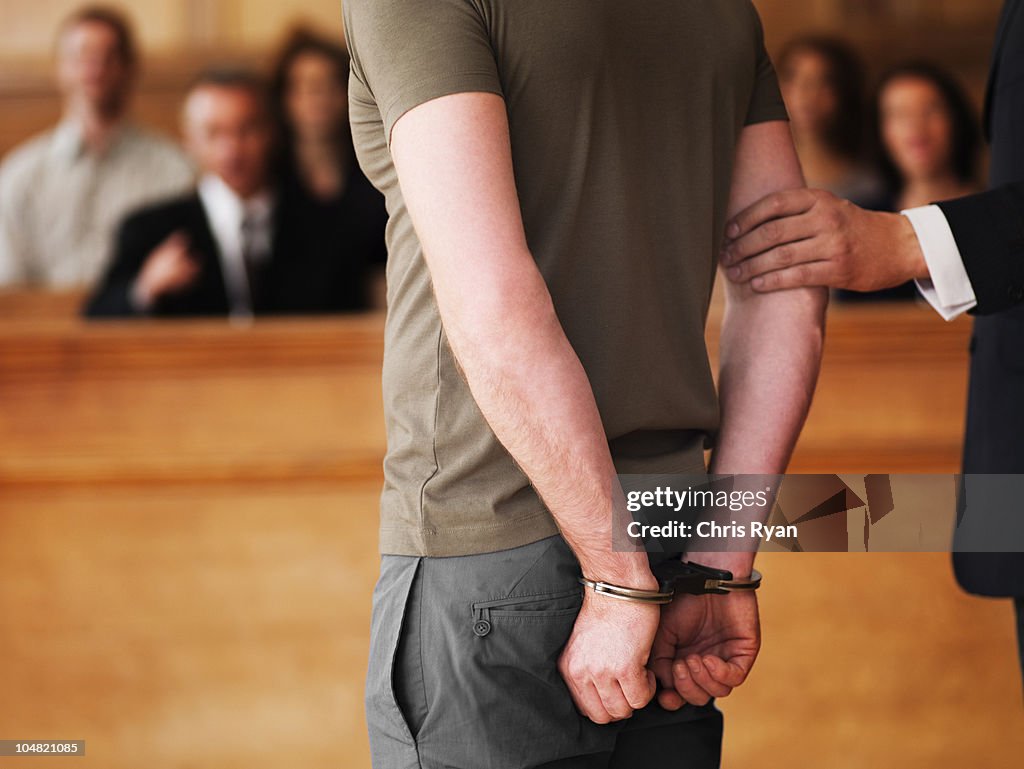 Handcuffed man standing in courtroom