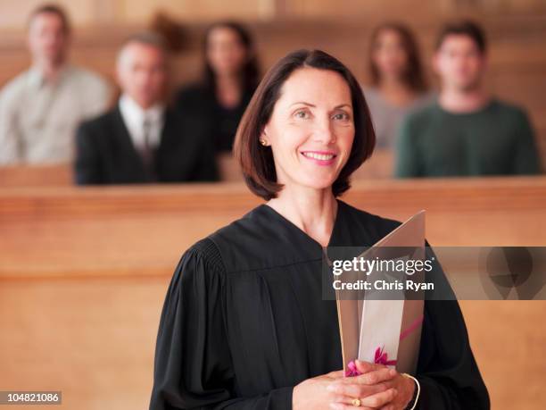 smiling judge holding file in courtroom - courtroom jurors judge stock pictures, royalty-free photos & images