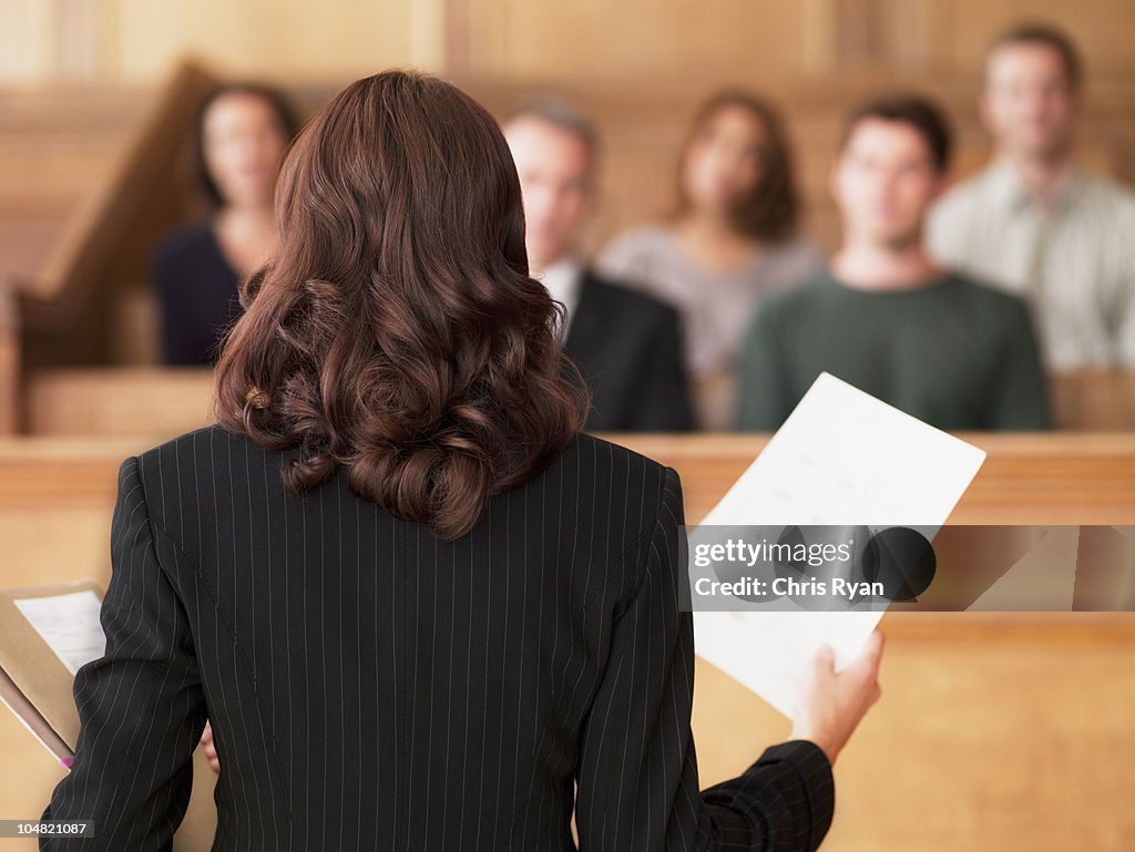 Anwalt holding Dokumente und sprechen jury im Gerichtssaal