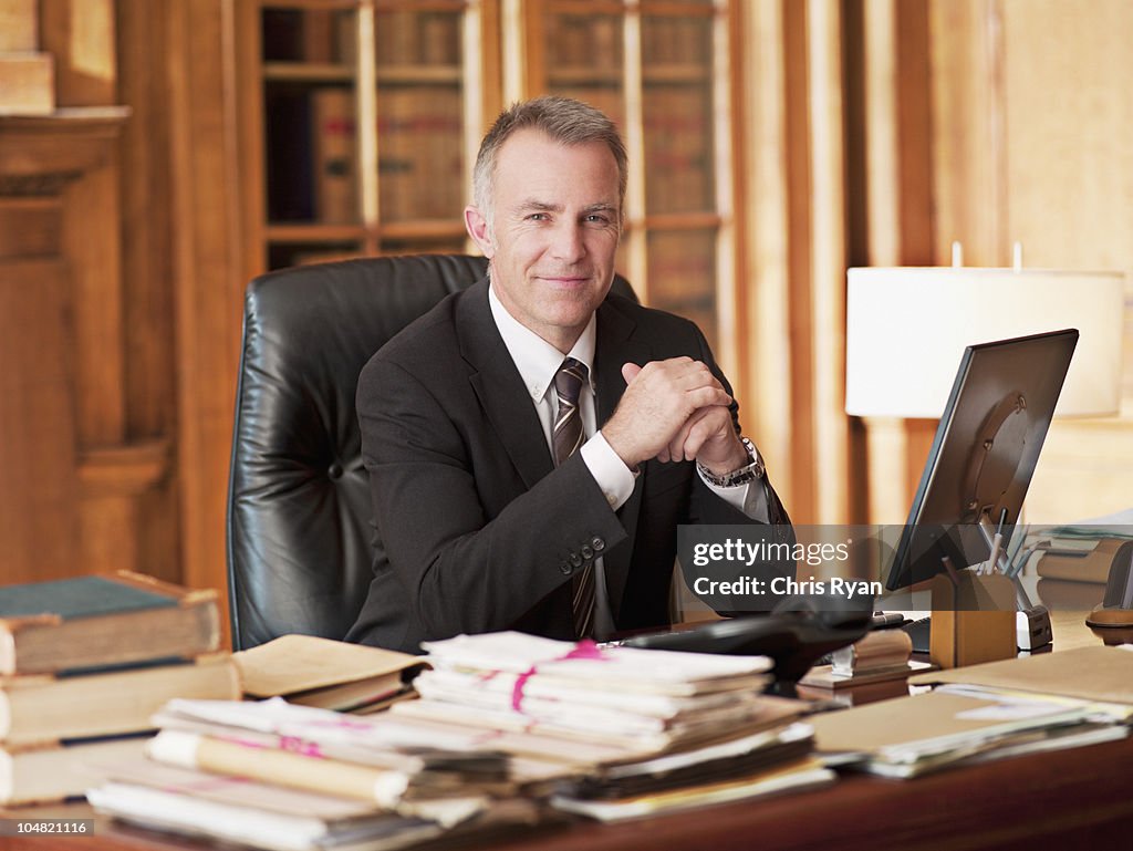 Smiling lawyer sitting at desk in office