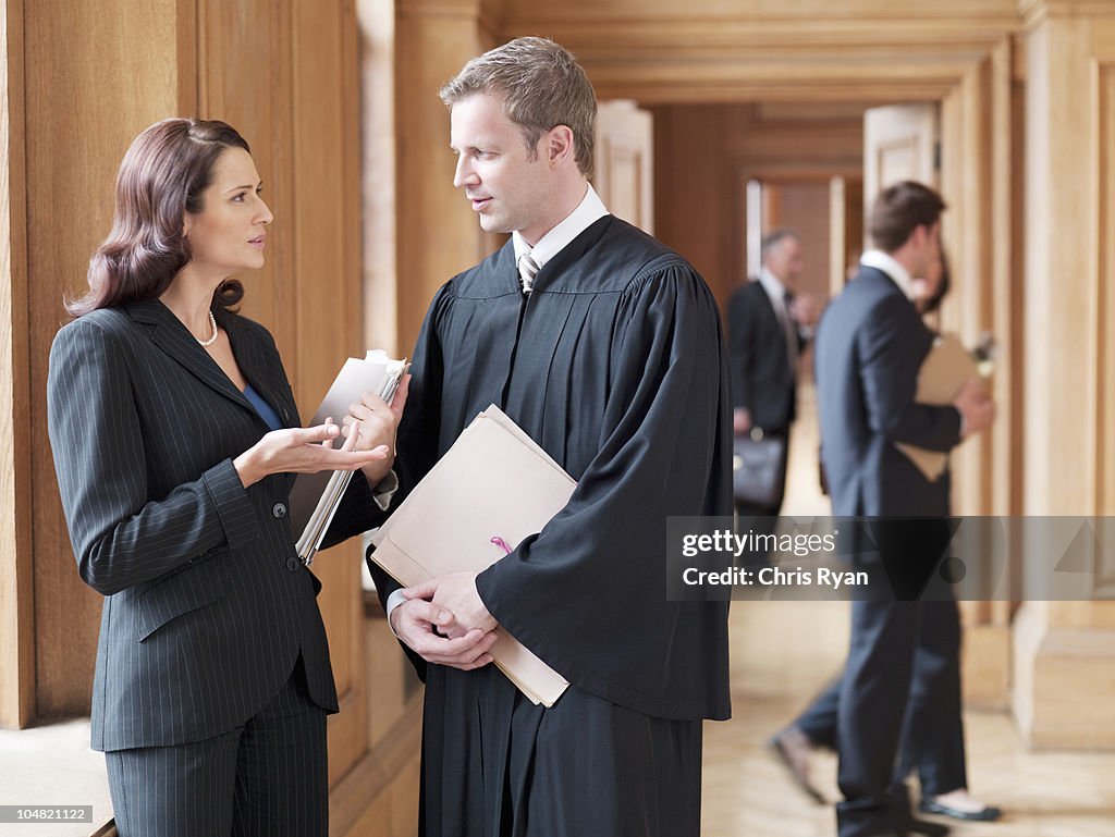 Judge and lawyer talking in corridor