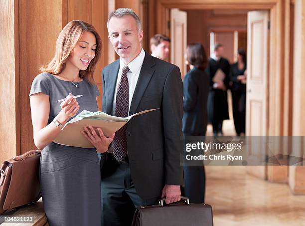 lawyers reviewing case file in corridor - lawyer explaining stock pictures, royalty-free photos & images