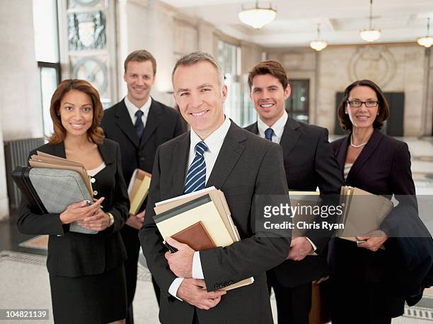sorridente avvocati con i file nella hall - difensore foto e immagini stock