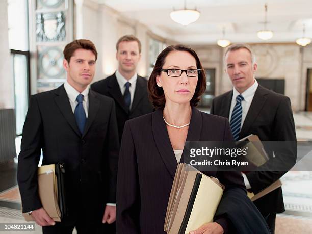 serious lawyers holding files in lobby - lawyers serious stock pictures, royalty-free photos & images