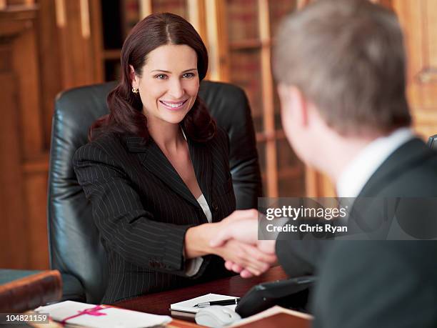 smiling lawyers shaking hands in office - lawyer woman stock pictures, royalty-free photos & images