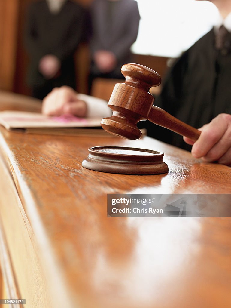 Close up of judge raising gavel in courtroom