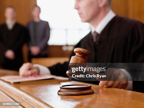 Judge holding gavel in courtroom Judge holding gavel in courtroom