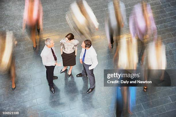 people rushing past business people talking - 長時間露出 ストックフォトと画像