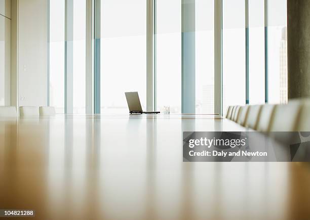 laptop sitting on table of empty conference room - board room table stock pictures, royalty-free photos & images